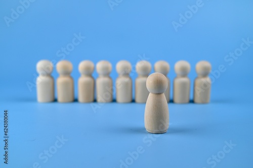 Wooden figure on a blue background with women as leader. Gender equality concepts. 