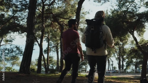two middle-aged guys are having a conversation and walking along a forest path. friendly meeting. bearded men