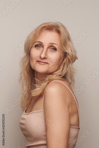 Beautiful blond middle aged woman smiling face looking camera portrait. Elegant mature lady no makeup 50 years old close-up isolated on white Women's health, cosmetology, skin care .