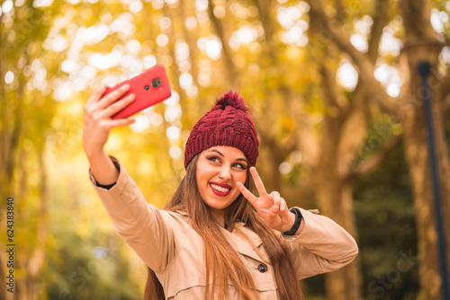 Portrait of a beautiful woman in autumn together in a forest in nature on a video call
