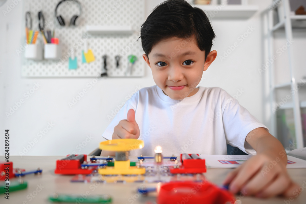 Asian Young Child Having Fun and Enjoy with Connecting Electronic Constructor. Learning and Experimentation with Circuit Board at Home. Develop the Brain, Practice Inventing for Future Innovators. Asian Young Child Having Fun and Enjoy with Connecting Electronic Constructor. Learning and Experimentation with Circuit Board at Home. Develop the Brain, Practice Inventing for Future Innovators.