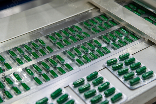 Capsules in a blister pack on a conveyor belt.