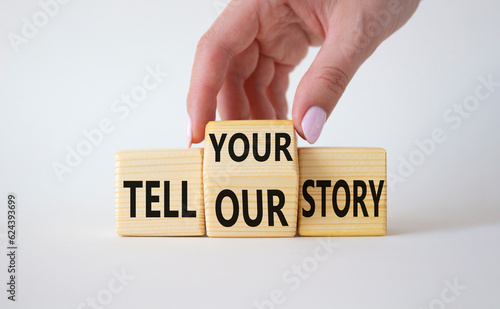Tell Your or Our story symbol. Businessman hand turns wooden cubes and changes the words Tell Our story to Tell Your story. Beautiful white background. Business concept. Copy space
