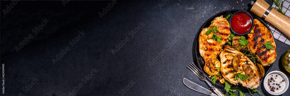 Grilled roasted chicken, turkey fillet. Spicy bbq fried white meat boneless fillet with garlic, rosemary, lemon and ketchup sauce, on black concrete table background top view copy space Grilled roasted chicken, turkey fillet. Spicy bbq fried white meat boneless fillet with garlic, rosemary, lemon and ketchup sauce, on black concrete table background top view copy space