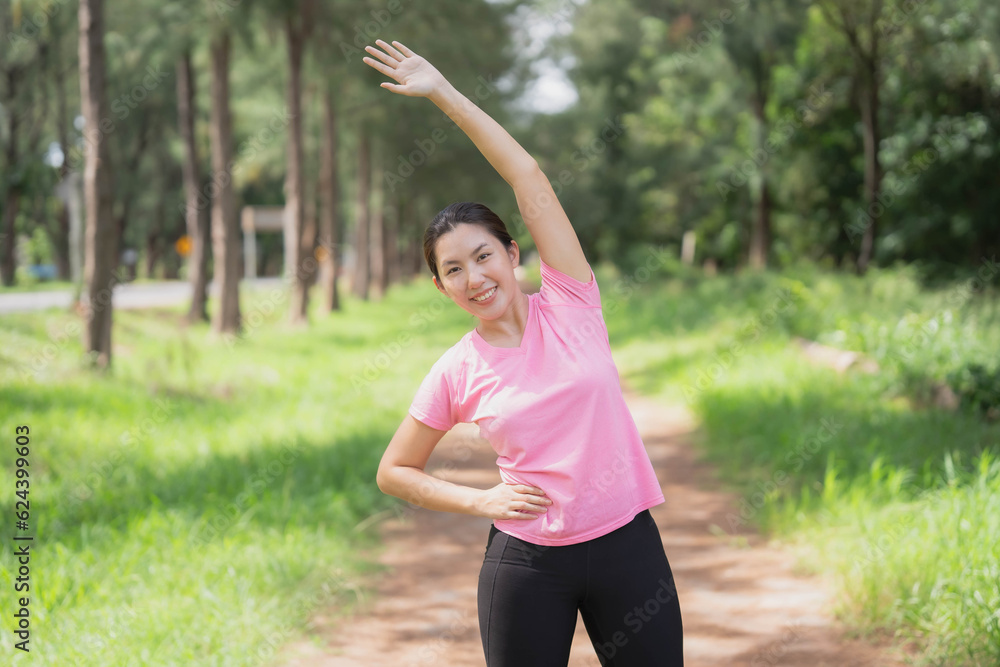 Asian woman wearing pink gym clothes Camlang warm up and stretch before running at the park. Asian woman wearing pink gym clothes Camlang warm up and stretch before running at the park.