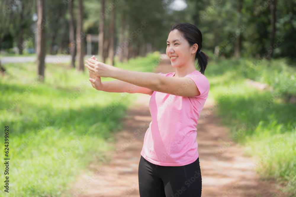 Asian woman wearing pink gym clothes Camlang warm up and stretch before running at the park. Asian woman wearing pink gym clothes Camlang warm up and stretch before running at the park.