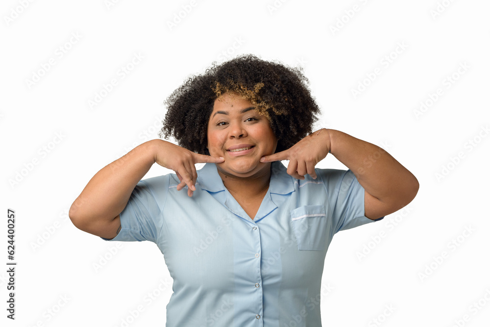 Waist up portrait of young Afro-Latin female dentist showing her smile with fingers Waist up portrait of young Afro-Latin female dentist showing her smile with fingers