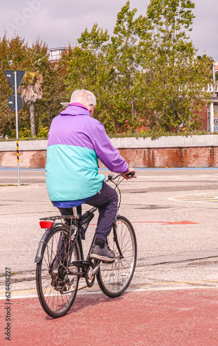 Senior, male riding a two wheel bike to church, on overcast day