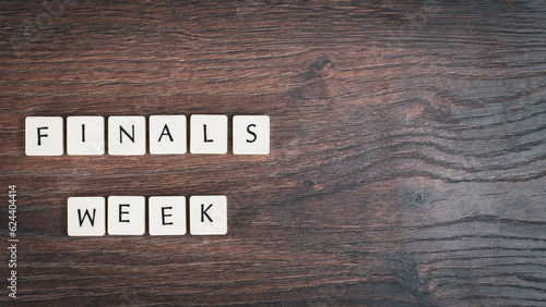 Back to school concept. Finals week word on wooden desk.