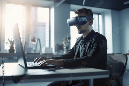 A person sitting at office and using VR glasses and laptop for working