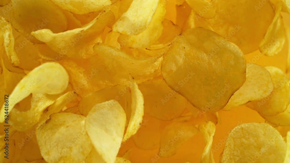 Super slow motion of flying fried potatoes chips on color gradient background. Filmed on high speed cinema camera, 1000 fps. Camera placed on high speed cine bot, tracking the target.