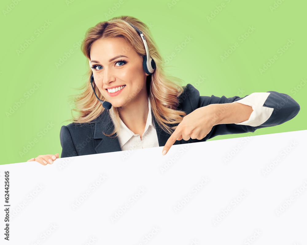 Call center. Customer support service female phone operator or sales agent in headset, grey confident suit pointing at mock up signboard with copy space for text, isolated over light green background. Call center. Customer support service female phone operator or sales agent in headset, grey confident suit pointing at mock up signboard with copy space for text, isolated over light green background.