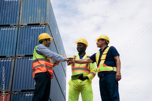 Team worker stack hand and shake hands to show success work at Container cargo harbor. Logistics concept inside the shipping, import, and export industries. .