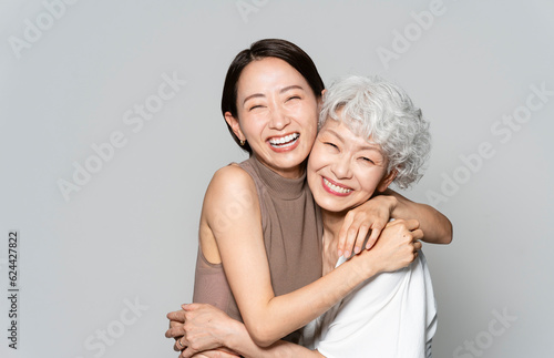 アジア人親子ポートレート、寄り添い笑っている/スタジオ撮影グレー背景	
 photo