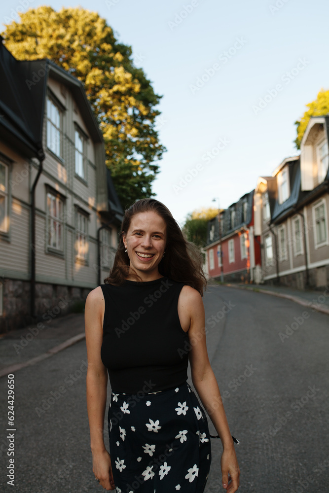 Frontal view of happy young woman walking down the street in Helsinki, Finland Frontal view of happy young woman walking down the street in Helsinki, Finland