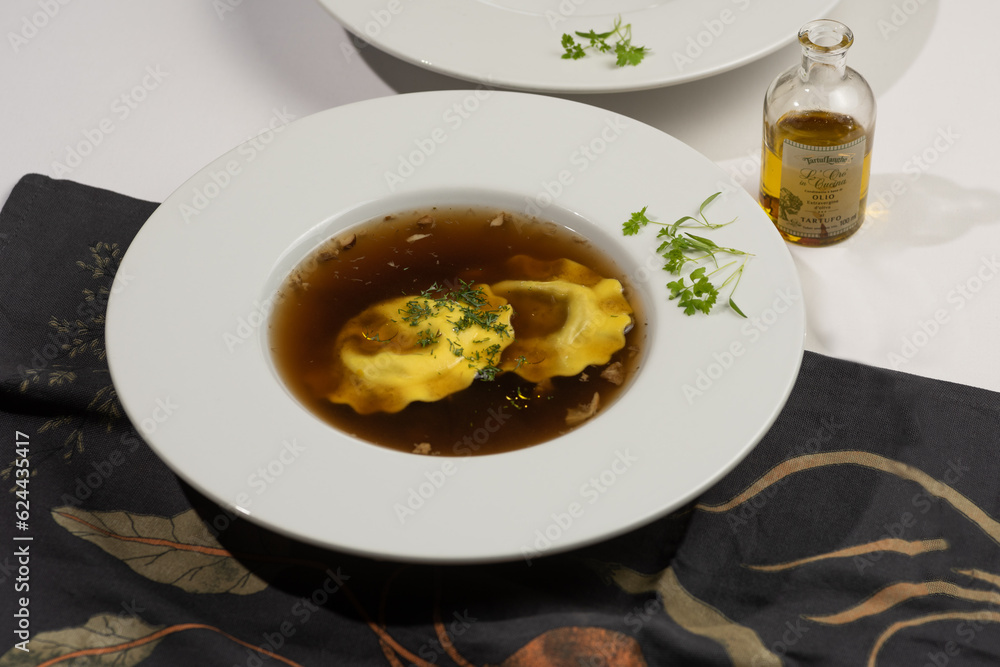White plates with mushroom soup and dumpling garnished with micro greens White plates with mushroom soup and dumpling garnished with micro greens
