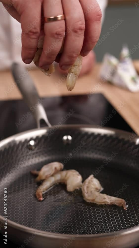 A chef prepares a shrimp dish in the kitchen. Close-up A chef prepares a shrimp dish in the kitchen. Close-up
