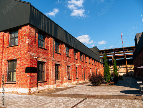 Modern cafe workspace exterior loft style red brick wall Old industrial building renovation. Creative urban space Break-out area city loft conversion brickwork warehouse design floor-to-ceiling window