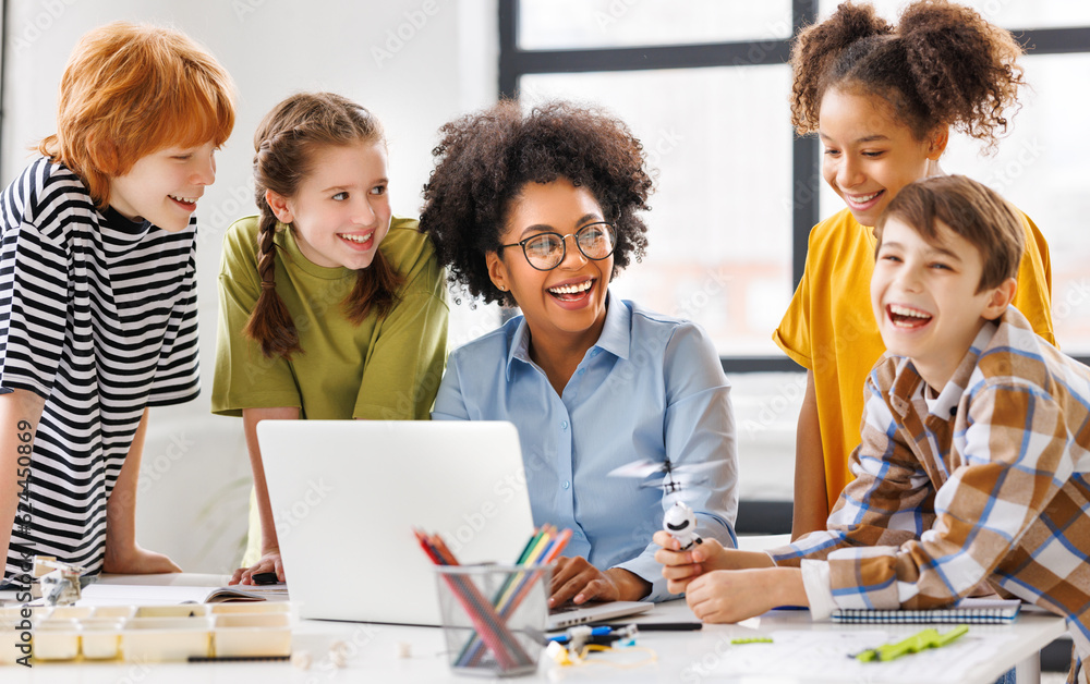 © JenkoAtaman - Teacher and students watching laptop screen.