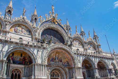 Fototapeta Details of St Mark's Basilica or the Basilica di San Marco in Italian, golden mosaics, intricate carvings, and statues adorn the roof of St