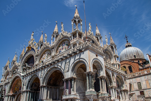 Details of St Mark's Basilica or the Basilica di San Marco in Italian, golden mosaics, intricate carvings, and statues adorn the roof of St. Mark's Basilica, a true marvel of Byzantine art in Venice. © Miros