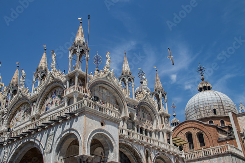 Details of St Mark's Basilica or the Basilica di San Marco in Italian, golden mosaics, intricate carvings, and statues adorn the roof of St. Mark's Basilica, a true marvel of Byzantine art in Venice.