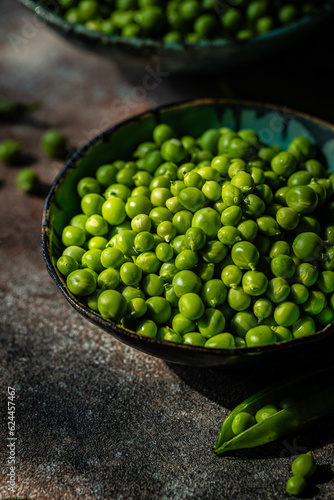 Bowl with fresh sweet peas on stone surface. © Sofiia.Popovych