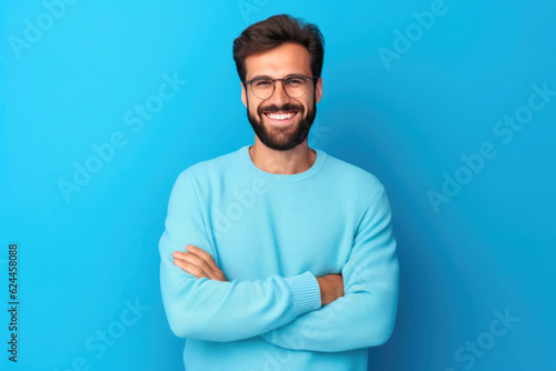 Confident bearded man exudes joy, rocking a casual sweater and glasses against a vibrant blue backdrop. Generative AI