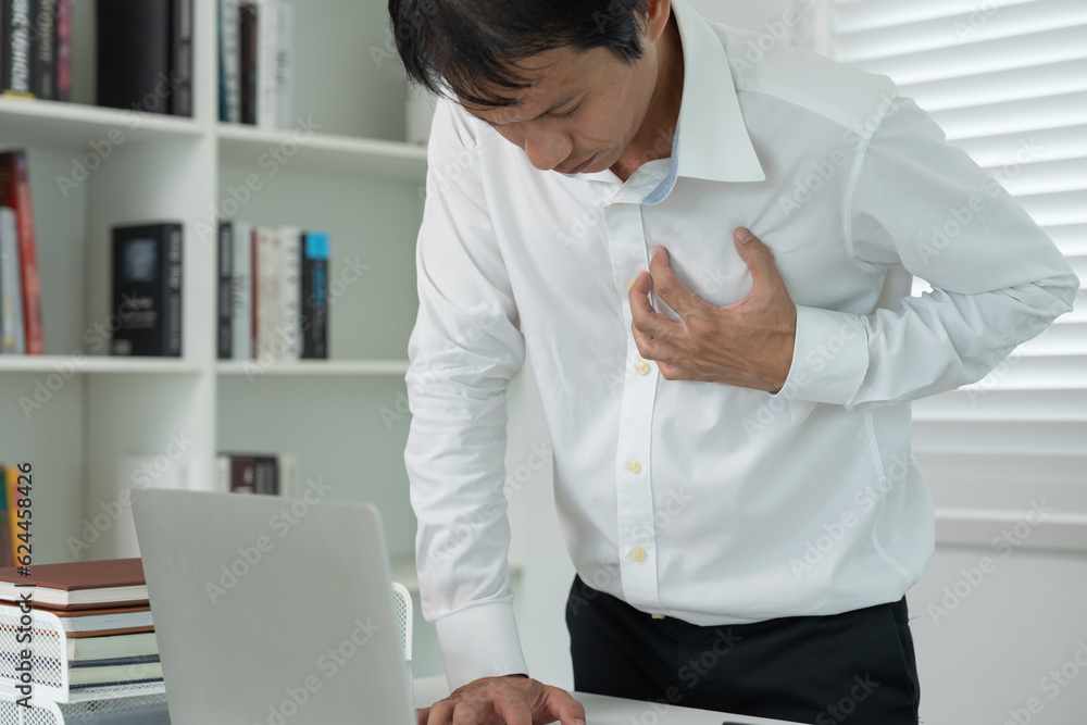 hand hold chest with heart attack symptoms, asian man working hard have