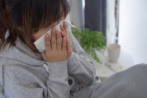 sick woman with a headache sitting under blanket, female sneezing and runny nose with seasonal influenza, allergic, high fever and influenza, resting, virus, coronavirus, feel illness, respiratory