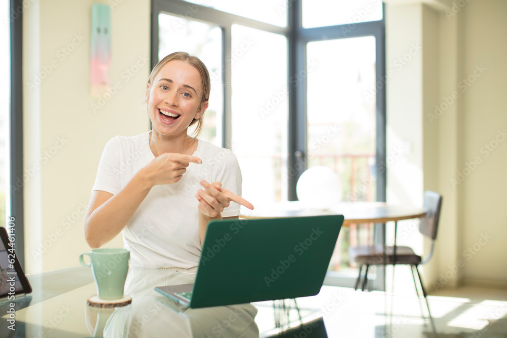 caucasian pretty woman with a laptop smiling cheerfully and pointing to copy space on palm on the side, showing or advertising an object caucasian pretty woman with a laptop smiling cheerfully and pointing to copy space on palm on the side, showing or advertising an object