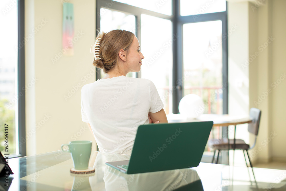 caucasian pretty woman with a laptop on profile view looking to copy space ahead, thinking, imagining or daydreaming caucasian pretty woman with a laptop on profile view looking to copy space ahead, thinking, imagining or daydreaming
