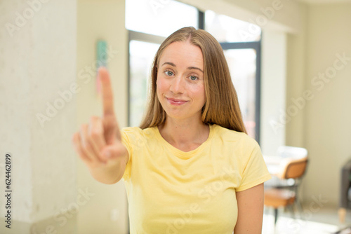 Wallpaper Mural pretty blond woman smiling proudly and confidently making number one pose triumphantly, feeling like a leader Torontodigital.ca