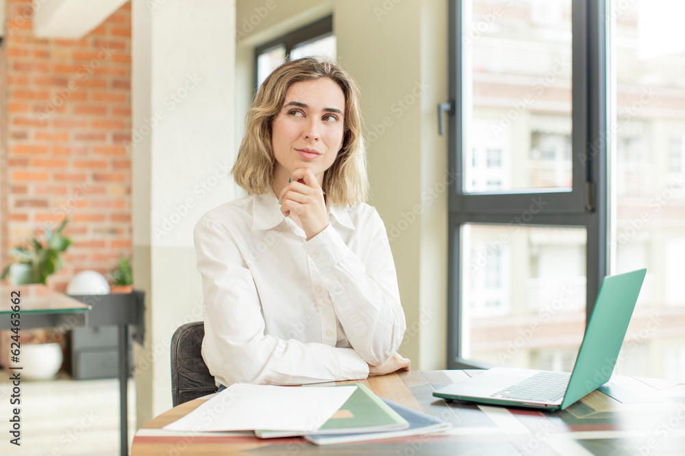 pretty woman smiling with a happy, confident expression with hand on chin. home work telecommuting concept pretty woman smiling with a happy, confident expression with hand on chin. home work telecommuting concept