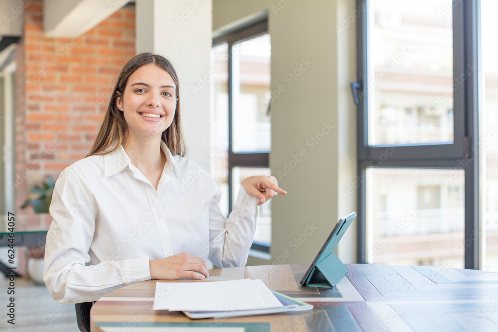young pretty woman smiling cheerfully, feeling happy and showing a concept. telecommuting concept young pretty woman smiling cheerfully, feeling happy and showing a concept. telecommuting concept
