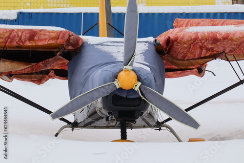 A small aircraft in winter in the snow at the airfield