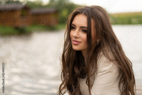 beautiful girl with long hair posing outdoors on the lake shore.