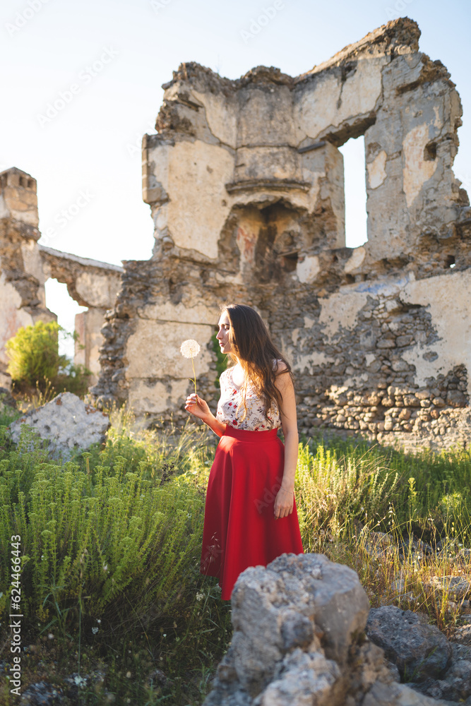 a beautiful girl in a red skirt among the ruins of the old town