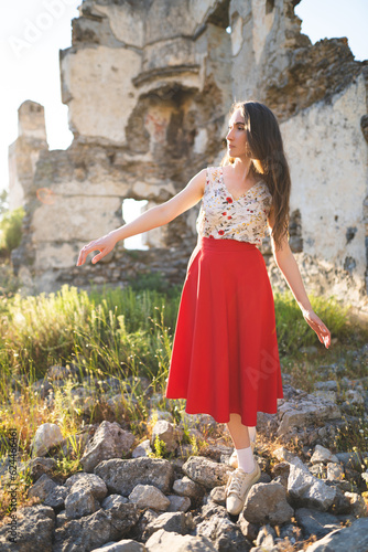 Cuadro en lienzo a beautiful girl in a red skirt among the ruins of the old town