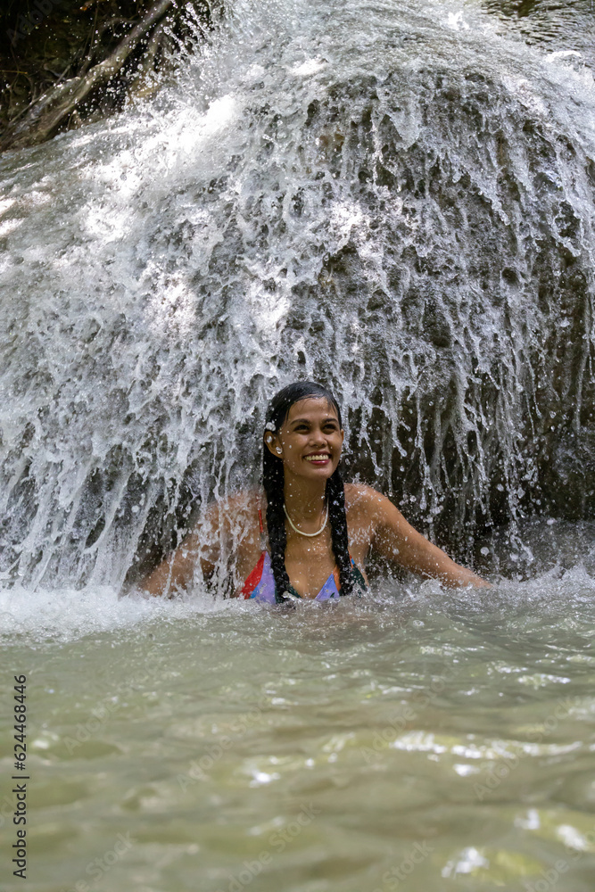 Fototapeta premium smiling girl in a waterfall