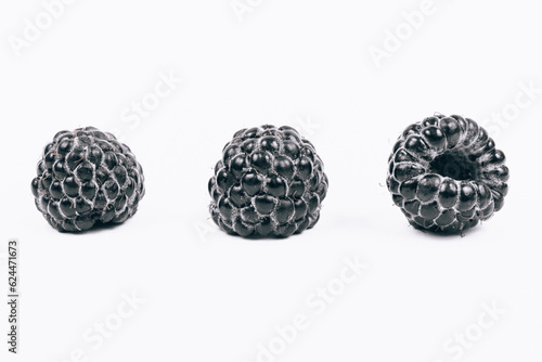 Macro shoot of sweet black raspberries on white background.