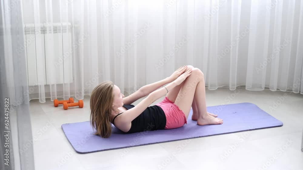 The girl at home shakes the press on the mat. The girl at home shakes the press on the mat.