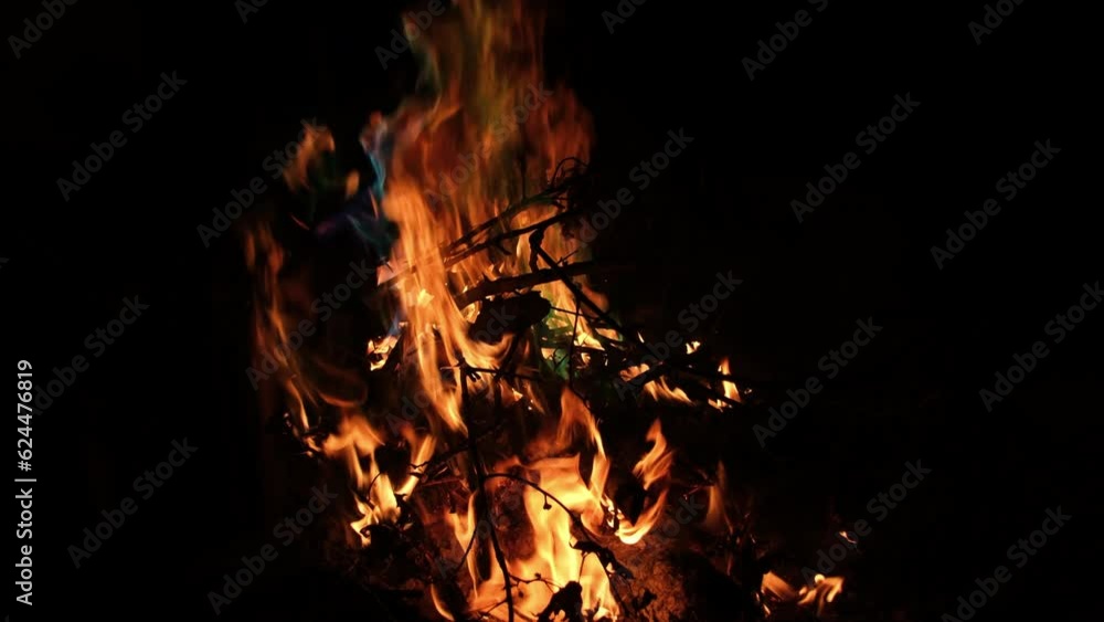 Slow motion of camp fire at night while burning wood sticks and some flames emitting blueish and greenish colors as if burning toxic materials in it. Slow motion of camp fire at night while burning wood sticks and some flames emitting blueish and greenish colors as if burning toxic materials in it.