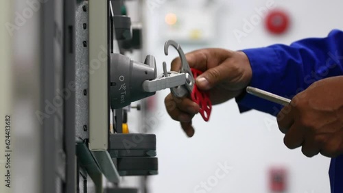 Locking and unlocking  LOTO of electric control cabinet keys before and after work for safety, industrial work and safety concept.