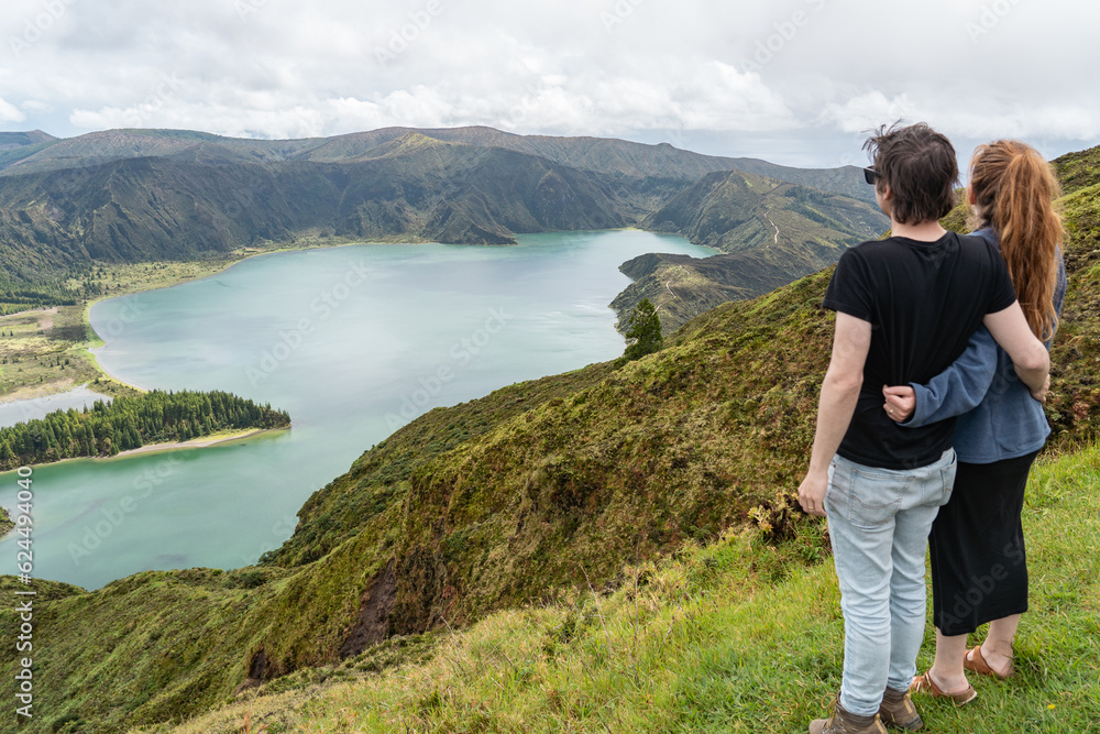 Couple looking at the incredible, enchanting view over the lagoa do Fogo in the Azores. 