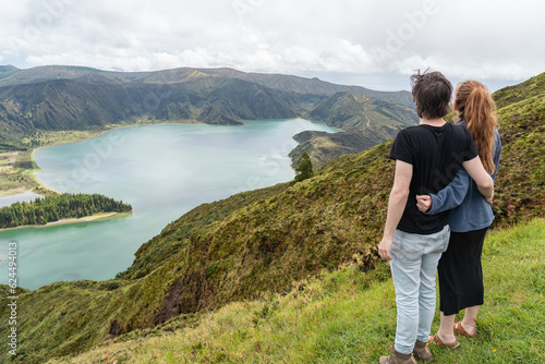 Couple looking at the incredible, enchanting view over the lagoa do Fogo in the Azores. 
