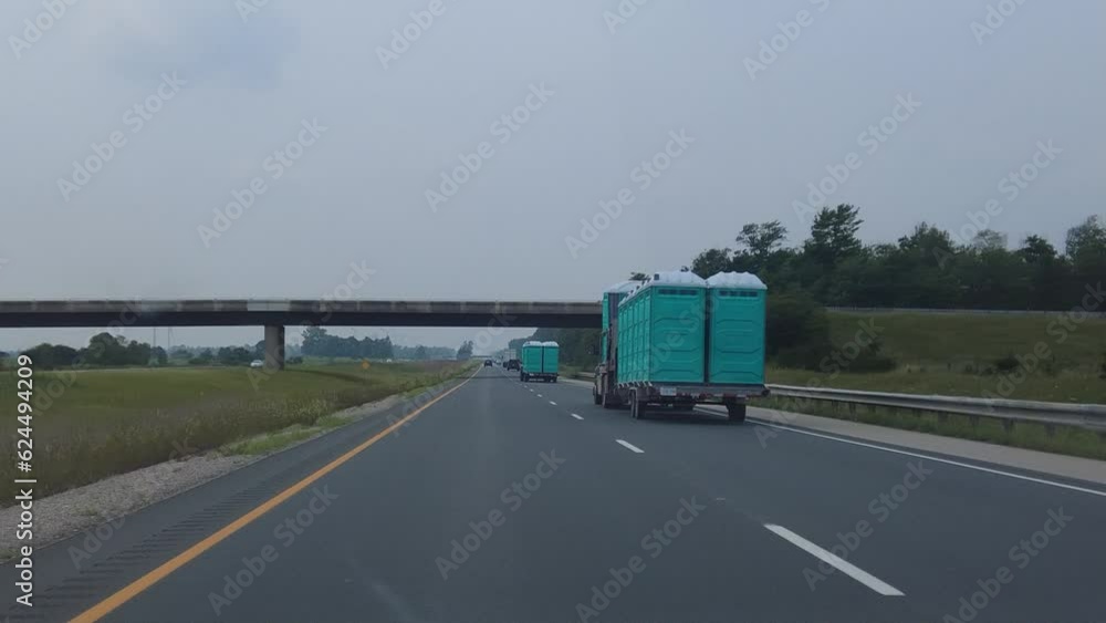 Sanitation Portapotties Being Transported On Highway Sanitation Portapotties Being Transported On Highway