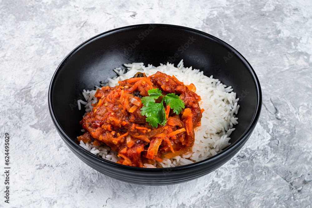 Boiled rice with stewed eggplants, sweet peppers, carrots, tomatoes, onions, sauce and parsley in a bowl. Boiled rice with stewed eggplants, sweet peppers, carrots, tomatoes, onions, sauce and parsley in a bowl.