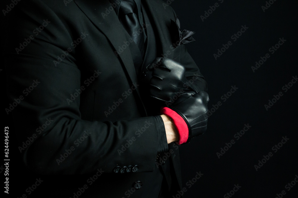 Mafia Gangster in Dark Suit Pulling on Black Leather Gloves. Threat of