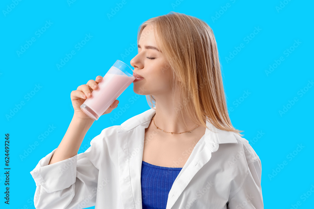 Young woman drinking tasty yoghurt on blue background Young woman drinking tasty yoghurt on blue background